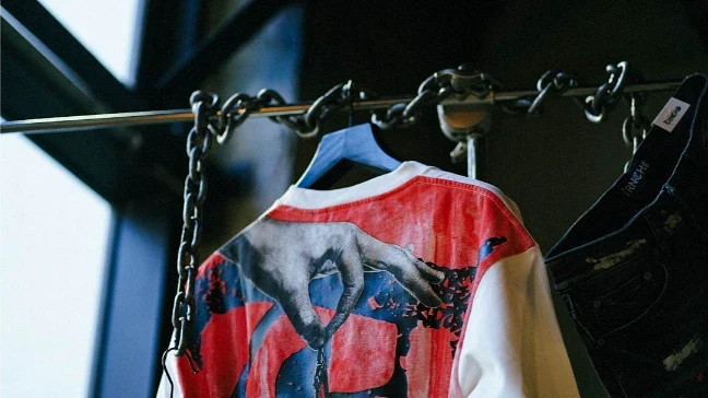 Printed jacket hanging from a chain rail in a clothing store