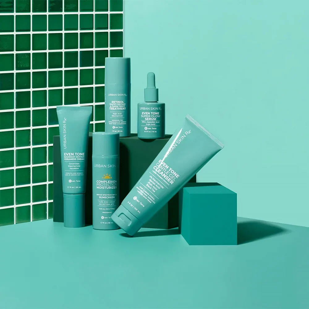 Urban Skin Rx skincare products on a teal set beside green tiles