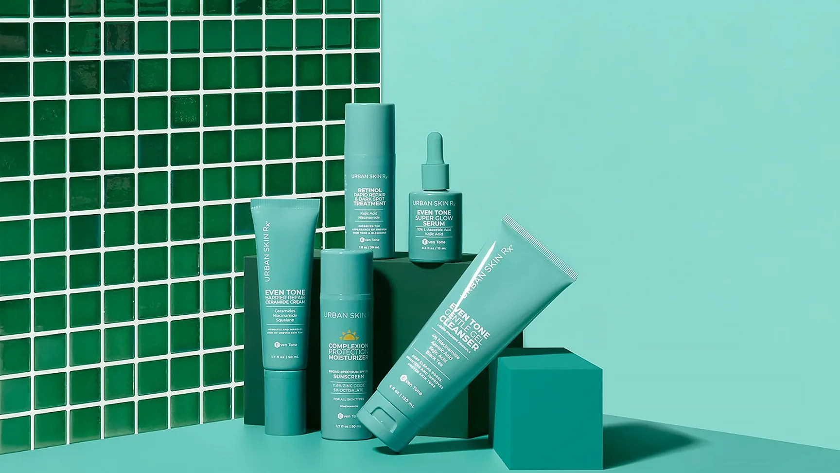 Urban Skin Rx Even Tone skincare range in teal packaging, set against a green tiled wall
